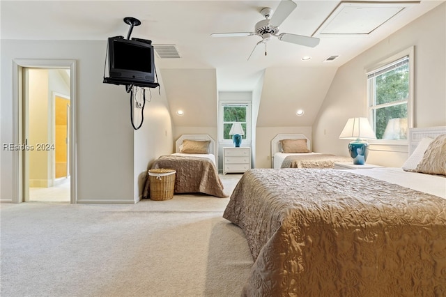 carpeted bedroom featuring multiple windows, connected bathroom, vaulted ceiling, and ceiling fan