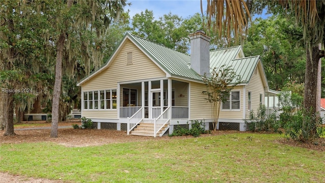 view of front of house with a sunroom and a front yard