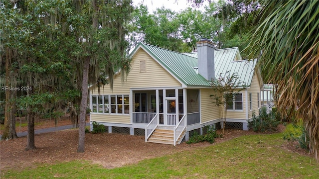 back of house featuring a sunroom and a yard