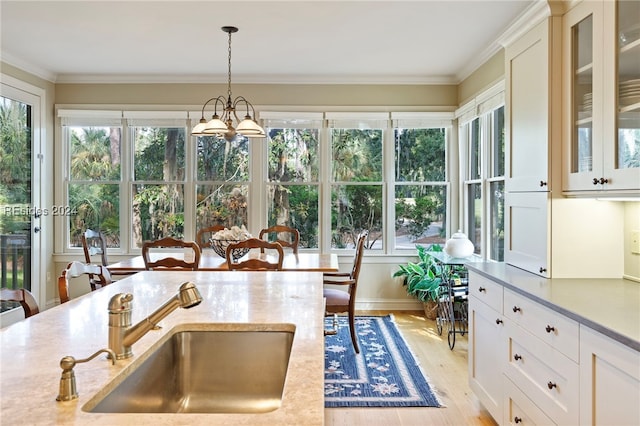 sunroom / solarium with sink, a wealth of natural light, and a notable chandelier