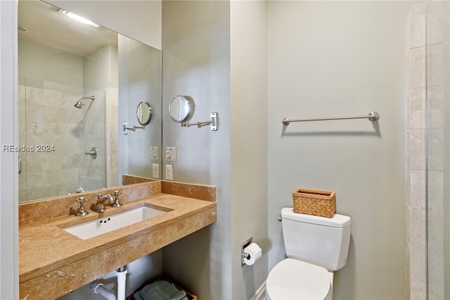 bathroom with sink, toilet, and tiled shower