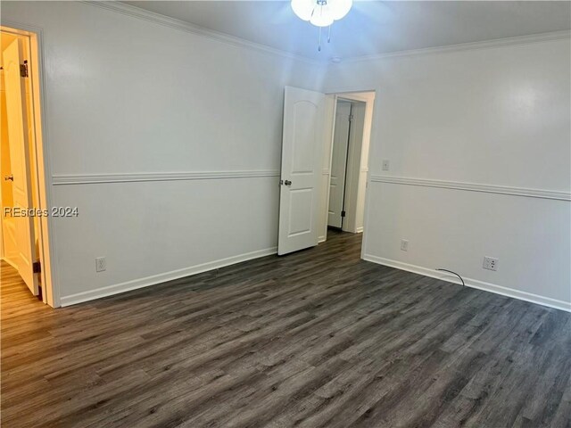 empty room featuring crown molding and dark hardwood / wood-style flooring