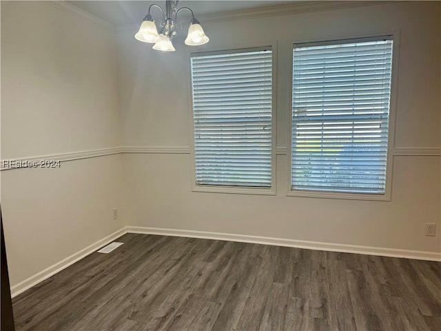 unfurnished room featuring an inviting chandelier, ornamental molding, and dark hardwood / wood-style floors