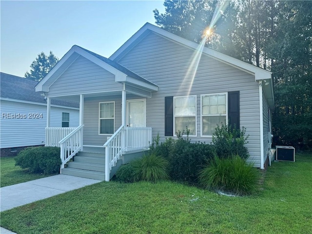 view of front facade featuring cooling unit and a front yard