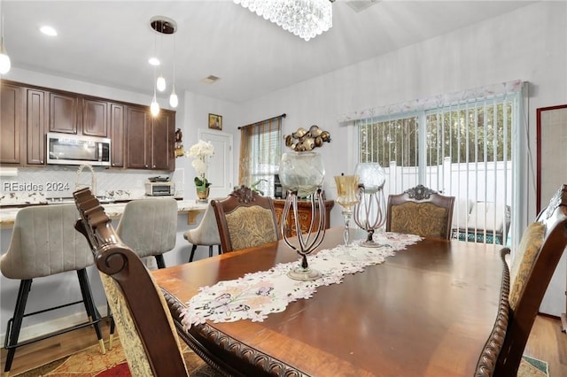 dining room featuring a chandelier and light wood-type flooring