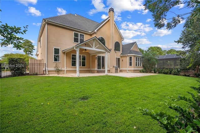 back of property with a patio, a yard, and ceiling fan