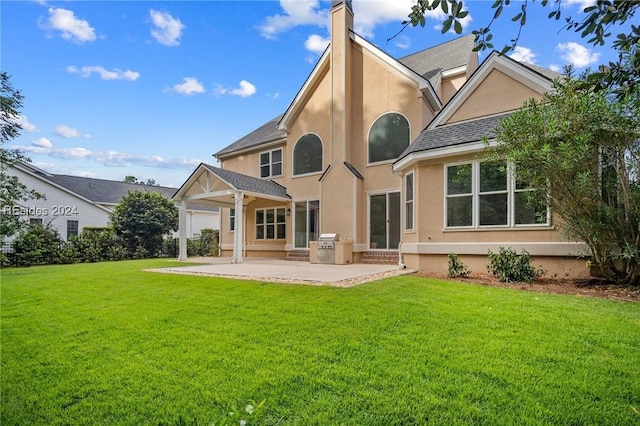 rear view of house featuring a patio area and a lawn