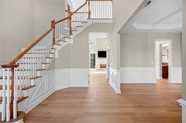 stairs featuring ornamental molding, sink, and hardwood / wood-style floors