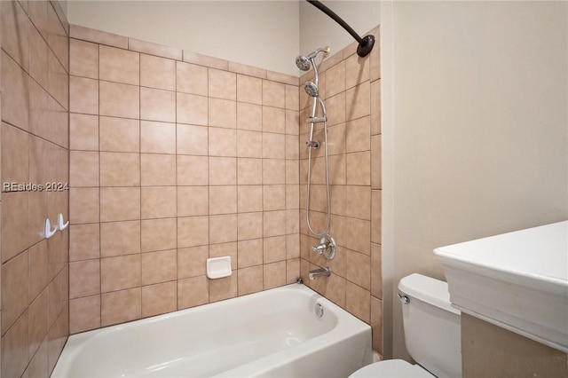 bathroom with toilet and tiled shower / bath combo