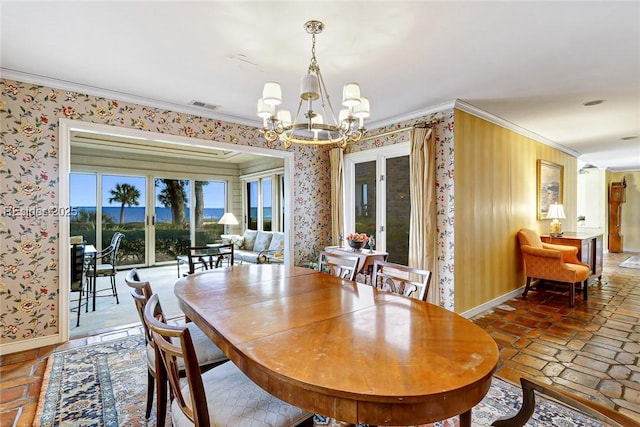 tiled dining space with crown molding and a chandelier