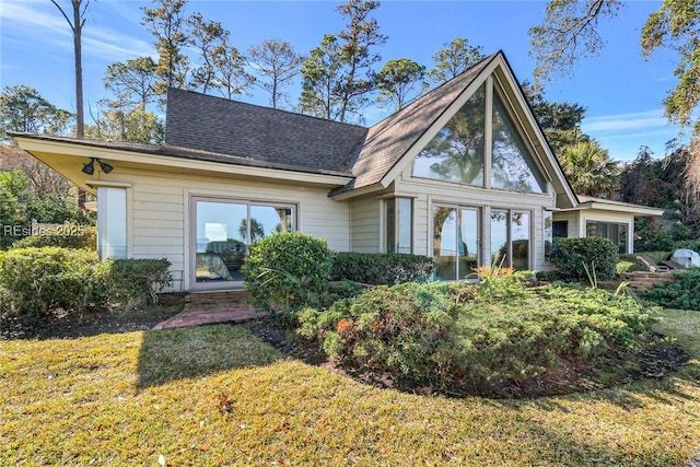 rear view of property featuring a lawn