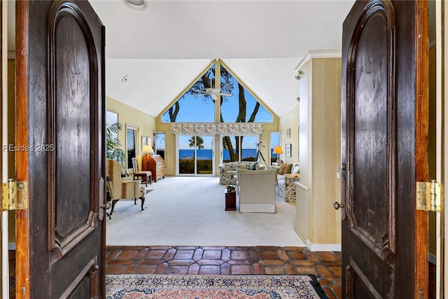 entrance foyer featuring lofted ceiling and dark carpet