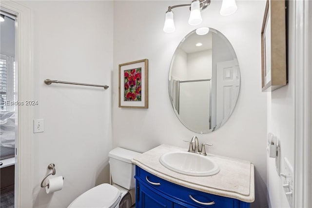 bathroom featuring vanity, toilet, and a shower with door