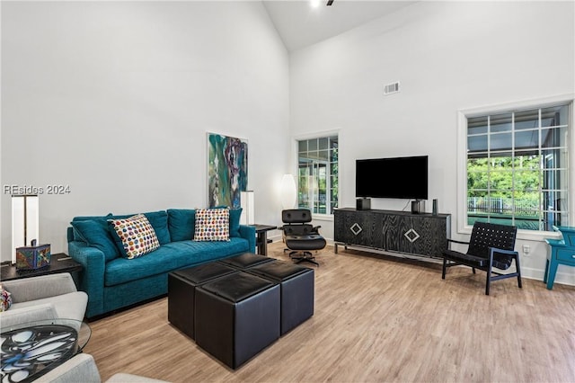 living room featuring high vaulted ceiling and light wood-type flooring