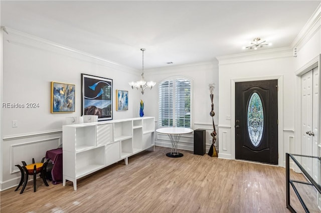 foyer featuring ornamental molding, a chandelier, and light hardwood / wood-style floors