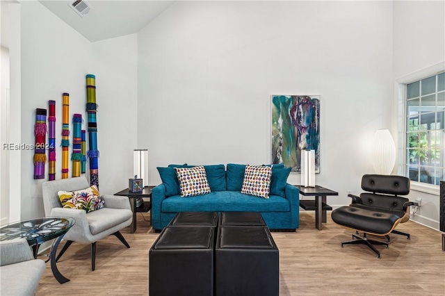 living room with vaulted ceiling and light wood-type flooring