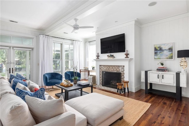 living room featuring ceiling fan, dark hardwood / wood-style floors, crown molding, and a fireplace