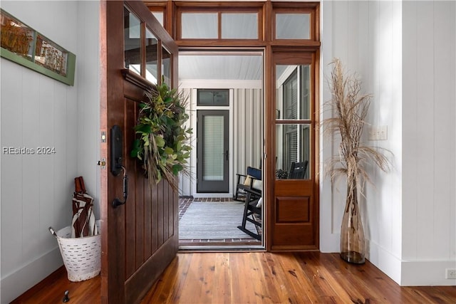 entrance foyer with wood-type flooring and wooden walls