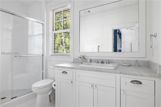 bathroom with vanity, toilet, tile patterned flooring, and a shower with door