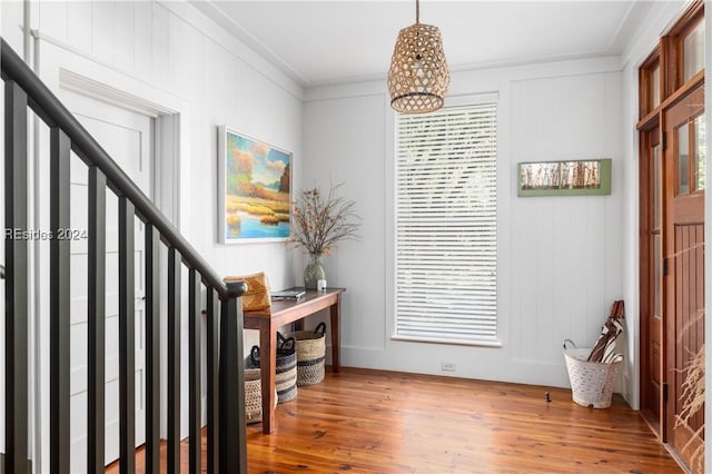 entrance foyer with hardwood / wood-style floors and crown molding