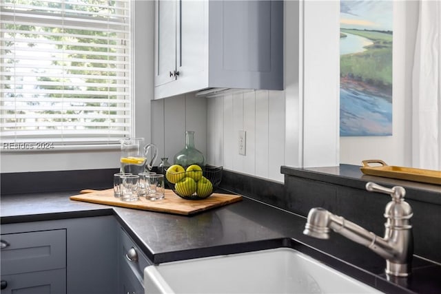 interior details with indoor wet bar and gray cabinetry