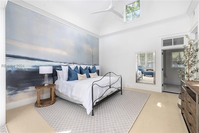 bedroom featuring crown molding, ceiling fan, and a high ceiling