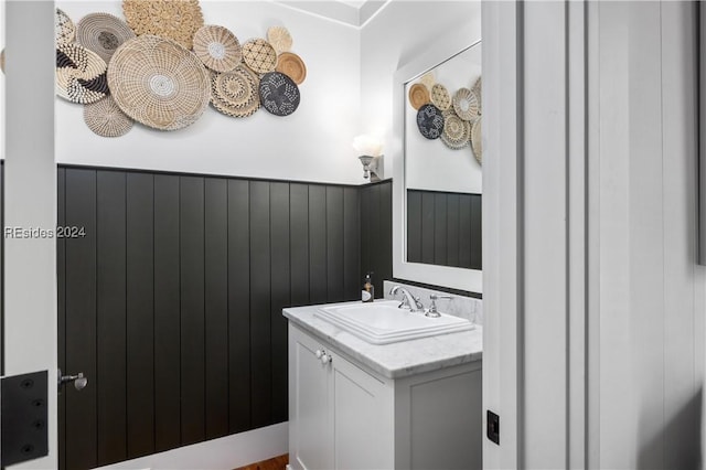 bathroom featuring vanity and wood walls