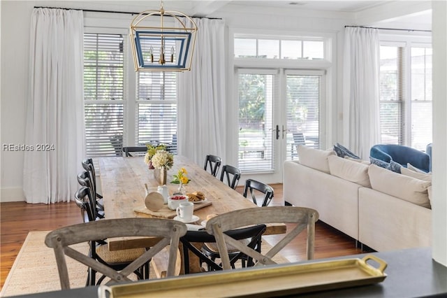 dining room with hardwood / wood-style floors, ornamental molding, and french doors