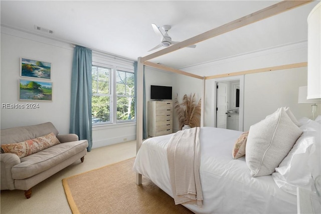 carpeted bedroom with crown molding, ceiling fan, and ensuite bath