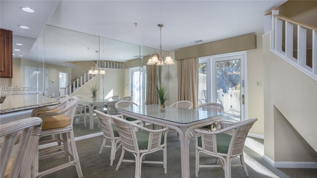 carpeted dining room with a notable chandelier