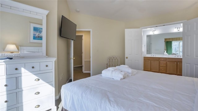 bedroom featuring ensuite bathroom and sink