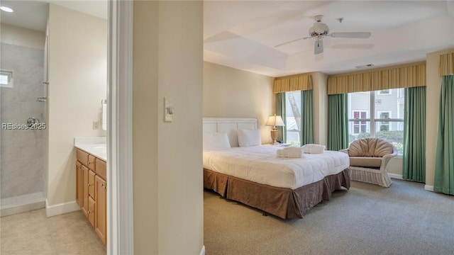 bedroom featuring light colored carpet, ceiling fan, and a tray ceiling