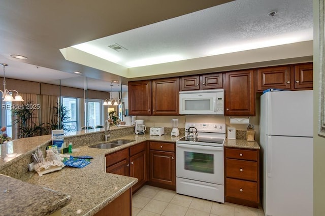 kitchen featuring sink, an inviting chandelier, white appliances, and decorative light fixtures