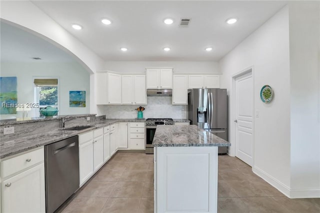 kitchen featuring stainless steel appliances, light stone countertops, sink, and white cabinets