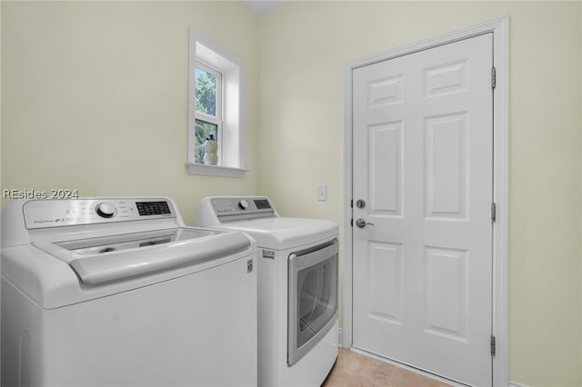 washroom featuring light tile patterned floors and washer and clothes dryer