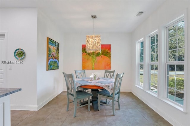 tiled dining room with a wealth of natural light and a notable chandelier