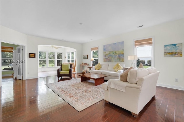 living room with dark wood-type flooring and ceiling fan