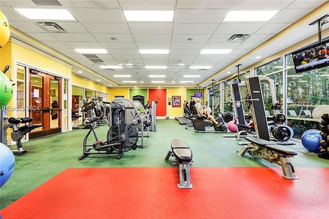 exercise room with a drop ceiling and carpet