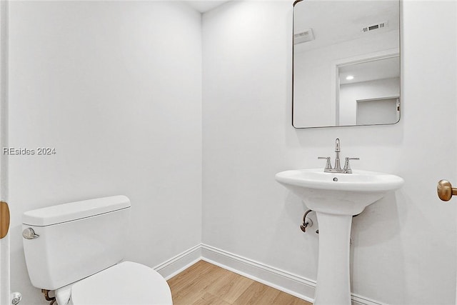 bathroom featuring sink, wood-type flooring, and toilet