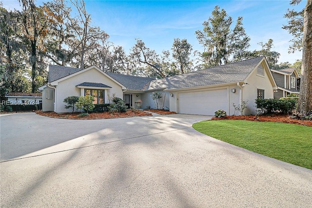 ranch-style house featuring a garage and a front lawn