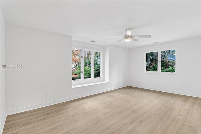 spare room featuring plenty of natural light, ceiling fan, and light hardwood / wood-style flooring