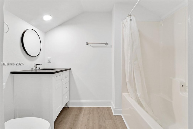 full bathroom with toilet, wood-type flooring, vaulted ceiling, vanity, and shower / bathtub combination with curtain