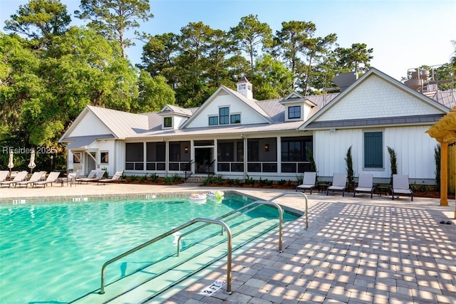 view of swimming pool with a patio area and a sunroom