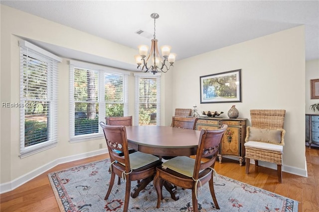 dining area featuring a notable chandelier and light wood-type flooring