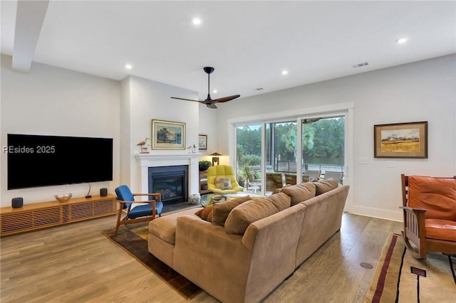 living room with ceiling fan and light hardwood / wood-style flooring