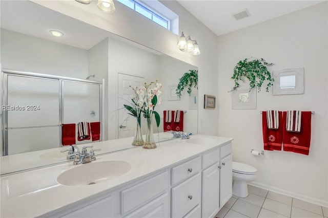 bathroom featuring a shower with door, vanity, tile patterned floors, and toilet