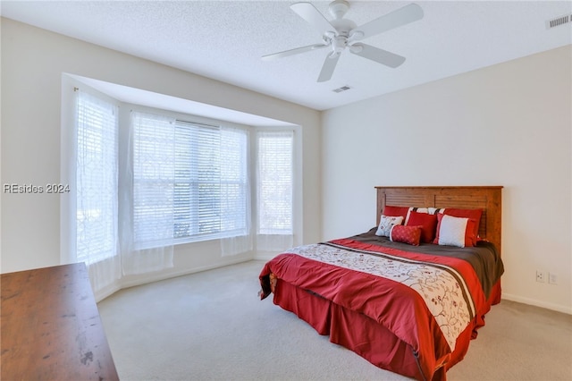 carpeted bedroom featuring a textured ceiling and ceiling fan