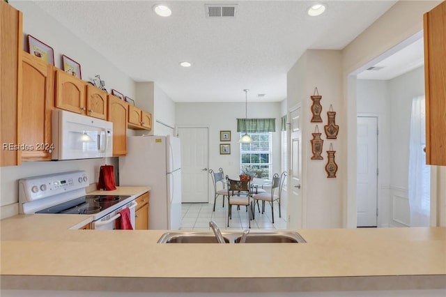 kitchen featuring hanging light fixtures, a textured ceiling, and white appliances