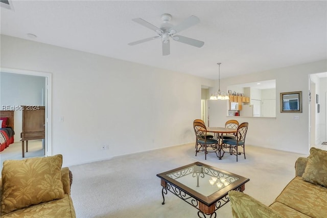 carpeted living room with ceiling fan with notable chandelier