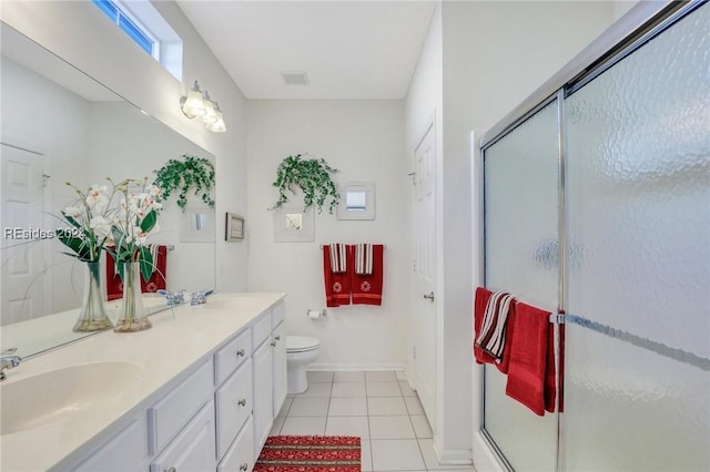 bathroom with vanity, tile patterned floors, a shower with door, and toilet